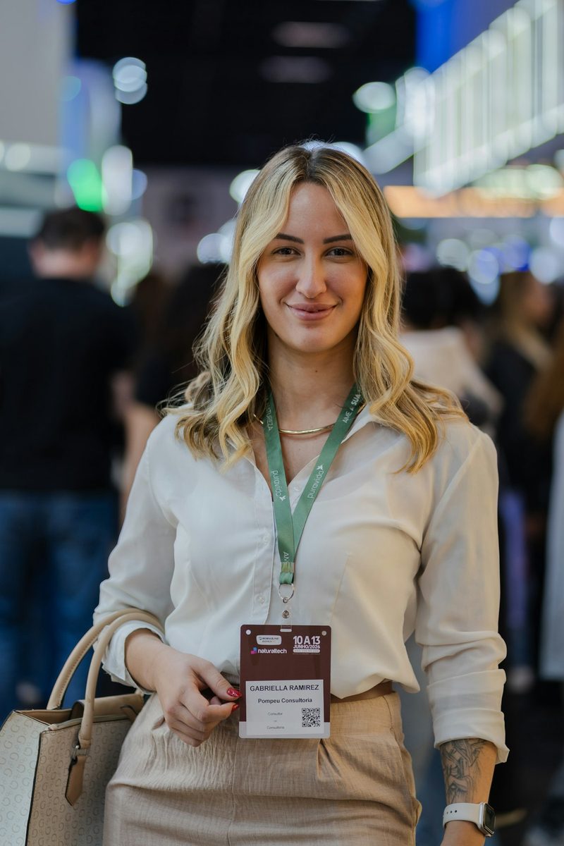 A smiling delegate wearing an event badge