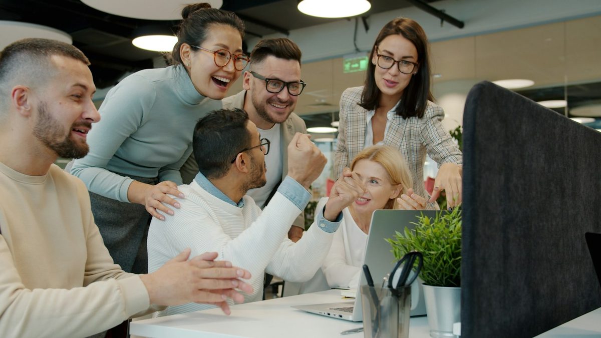 A team celebrating together at their desks